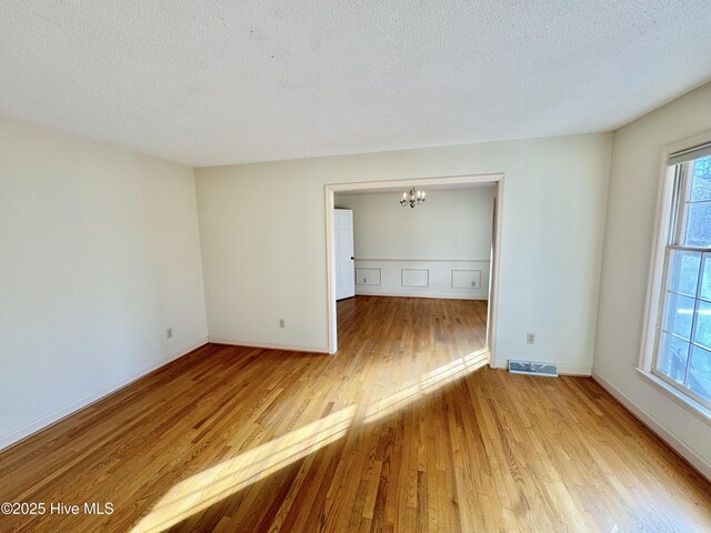 unfurnished room featuring crown molding, light hardwood / wood-style floors, and a textured ceiling