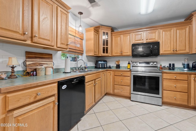 kitchen with tasteful backsplash, pendant lighting, sink, and black appliances