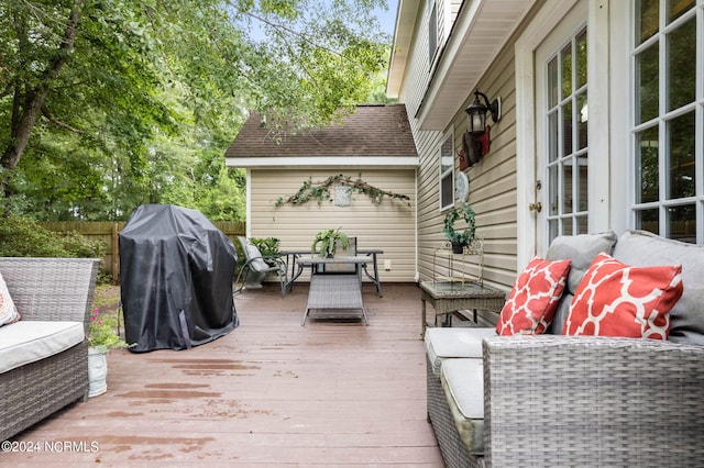 wooden deck with an outdoor living space and grilling area