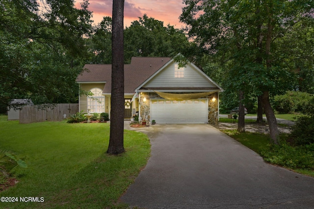 view of front of house with a garage and a yard