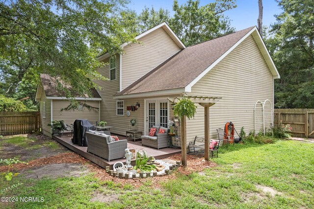 rear view of property with a wooden deck, outdoor lounge area, and a yard