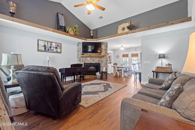 living room featuring a stone fireplace, ceiling fan, hardwood / wood-style flooring, and high vaulted ceiling