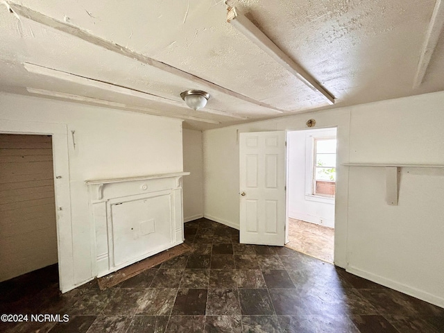 basement with a textured ceiling and baseboards