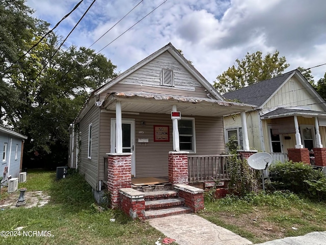 bungalow-style home featuring a porch and cooling unit