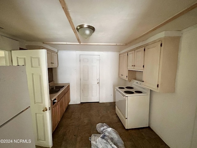 kitchen with white appliances, dark wood finished floors, light countertops, and a sink