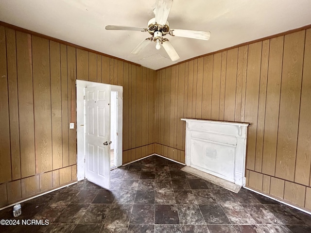 interior space featuring wooden walls and a ceiling fan