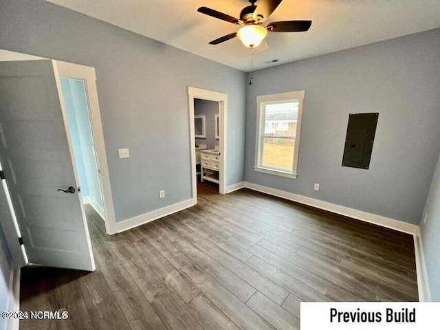 unfurnished bedroom featuring hardwood / wood-style floors, connected bathroom, electric panel, and ceiling fan