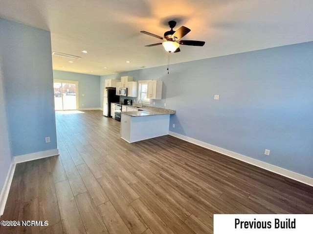 kitchen with refrigerator, kitchen peninsula, hardwood / wood-style flooring, ceiling fan, and white cabinets