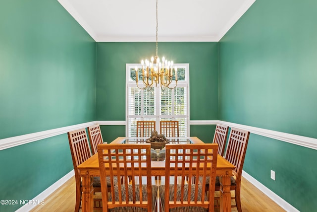 dining room with an inviting chandelier, ornamental molding, and light hardwood / wood-style floors