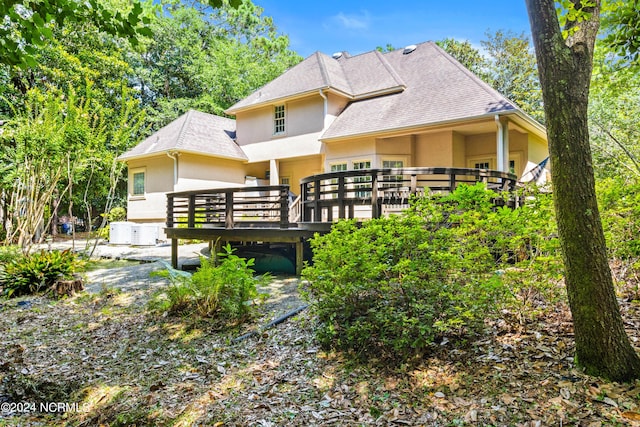 back of house with central air condition unit and a deck