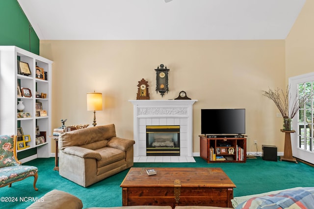 living room featuring a tile fireplace, vaulted ceiling, and carpet