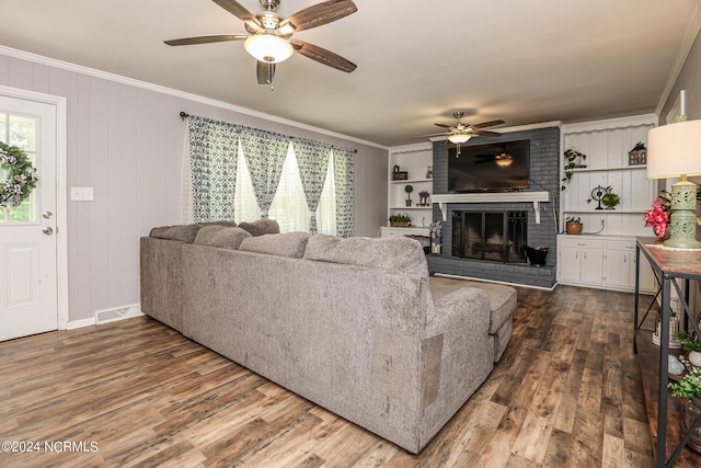 living room with a fireplace, ornamental molding, and a healthy amount of sunlight