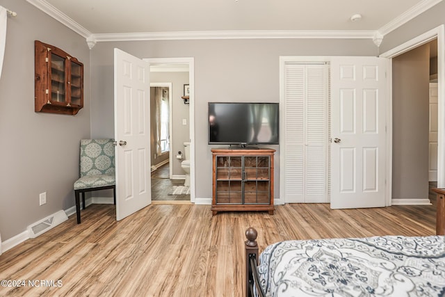 bedroom featuring ornamental molding, light hardwood / wood-style floors, and a closet