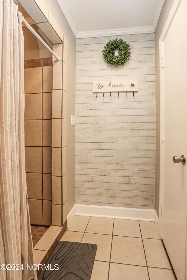 mudroom with ornamental molding, wood walls, and light tile patterned flooring