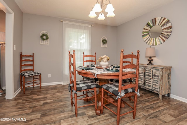 dining room with dark wood-type flooring and a chandelier