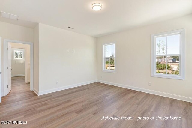 unfurnished room with a wealth of natural light and hardwood / wood-style floors