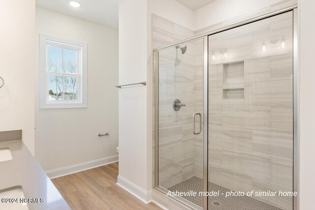 bathroom with walk in shower and hardwood / wood-style floors