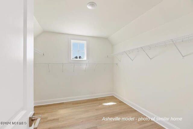 walk in closet featuring lofted ceiling and light hardwood / wood-style flooring