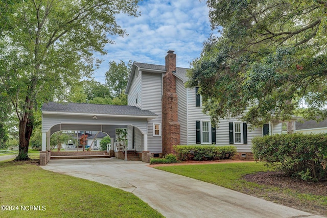 view of front of property with a front lawn and a carport