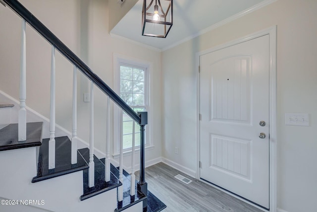 entryway featuring light wood-type flooring and ornamental molding