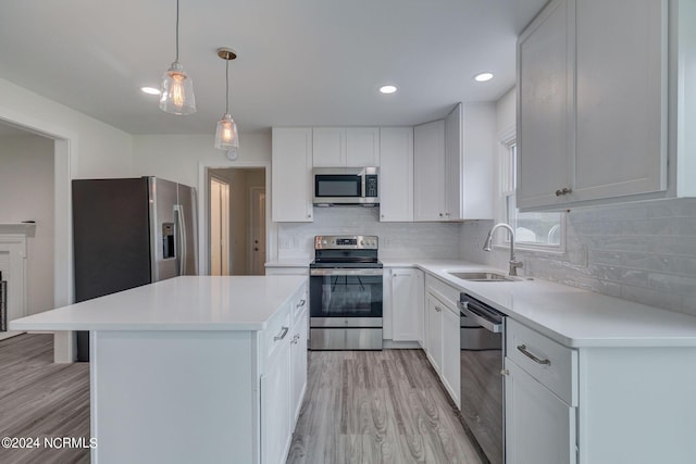 kitchen featuring white cabinetry, sink, light hardwood / wood-style flooring, a kitchen island, and appliances with stainless steel finishes