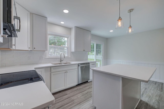 kitchen featuring dishwasher, sink, a kitchen island, light hardwood / wood-style flooring, and white cabinets