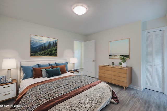 bedroom with light hardwood / wood-style flooring and a closet