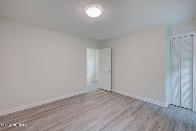 unfurnished bedroom featuring light wood-type flooring and a closet