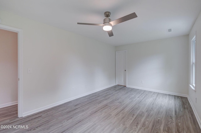 empty room with ceiling fan and light hardwood / wood-style flooring