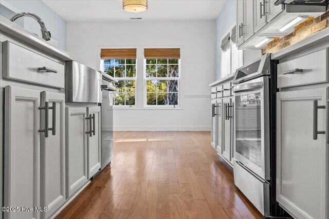 kitchen with stainless steel refrigerator with ice dispenser, backsplash, and white cabinets