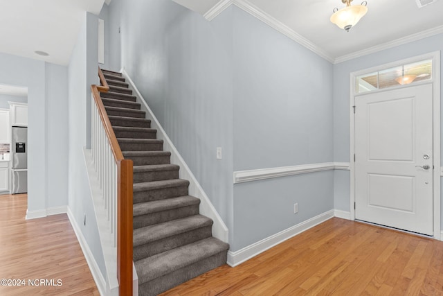 entryway featuring crown molding and light hardwood / wood-style floors