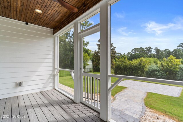 rear view of property featuring a patio area, a sunroom, and a lawn