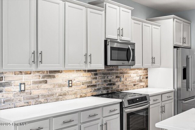 kitchen featuring electric stove, light stone counters, and white cabinets