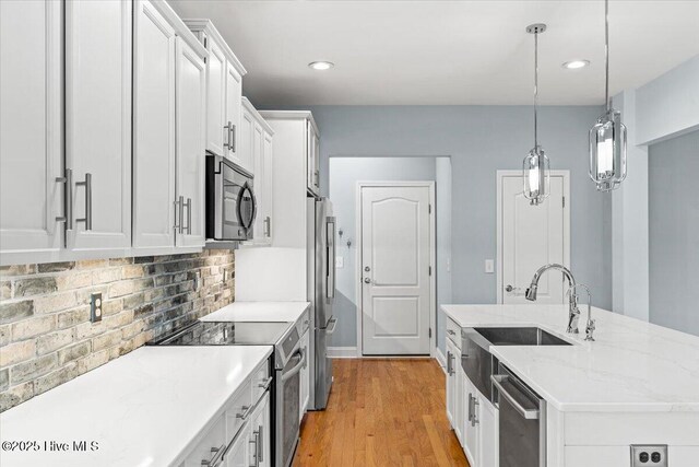 kitchen featuring white cabinets, backsplash, and appliances with stainless steel finishes