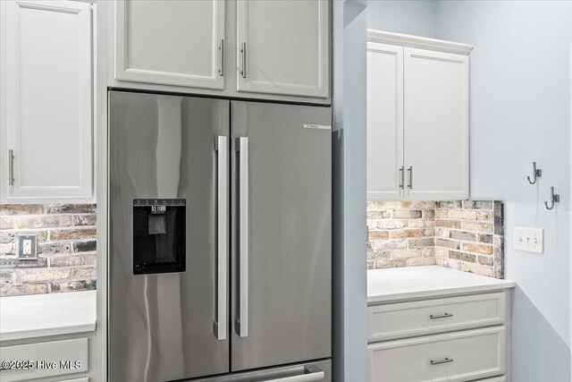 kitchen with sink, stainless steel appliances, light stone counters, white cabinets, and decorative light fixtures