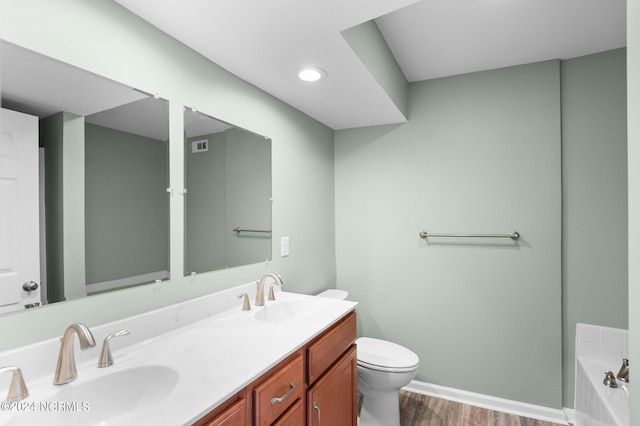 bathroom with vanity, toilet, a bathtub, and wood-type flooring