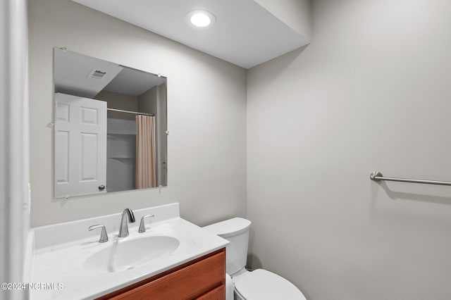 bathroom with vanity, toilet, and curtained shower