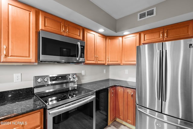 kitchen with wine cooler, appliances with stainless steel finishes, and dark stone counters