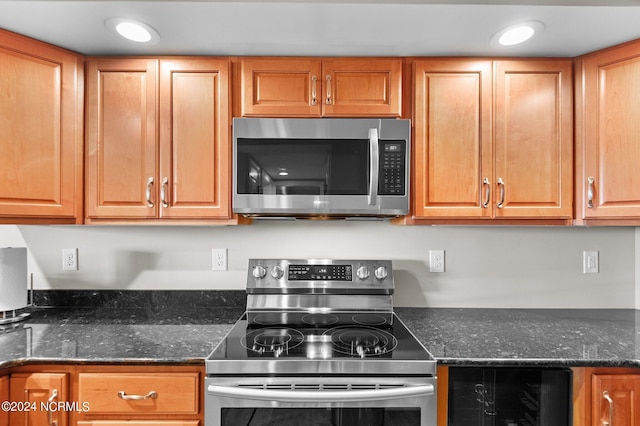 kitchen featuring wine cooler, dark stone counters, and appliances with stainless steel finishes