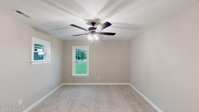 empty room with ceiling fan and light carpet