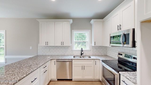 kitchen with white cabinetry, stainless steel appliances, and sink