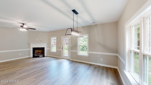 unfurnished living room featuring ceiling fan and wood-type flooring