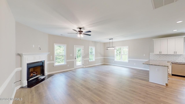 unfurnished living room featuring ceiling fan and light wood-type flooring