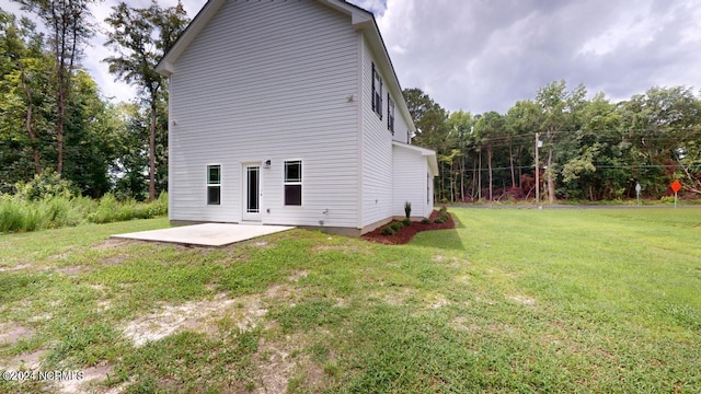 rear view of property featuring a lawn and a patio area