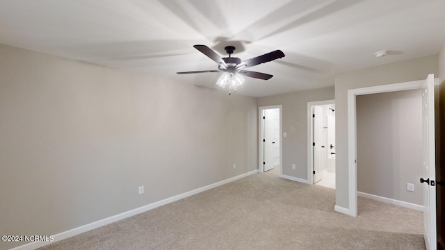 unfurnished bedroom with ensuite bathroom, light carpet, and ceiling fan