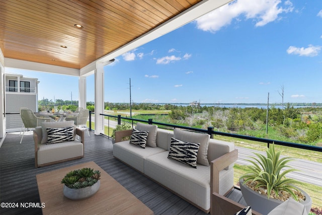 wooden deck with an outdoor living space and a water view