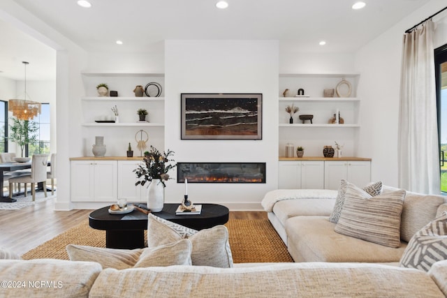 living room featuring built in features and light hardwood / wood-style flooring