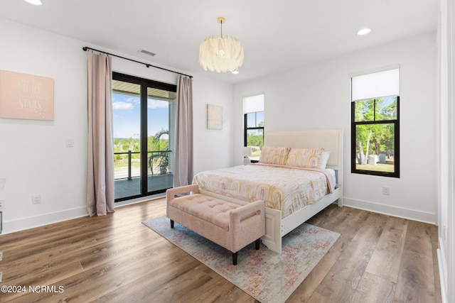 bedroom featuring multiple windows, access to outside, and wood-type flooring