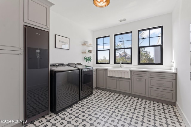 washroom featuring cabinets, separate washer and dryer, and sink