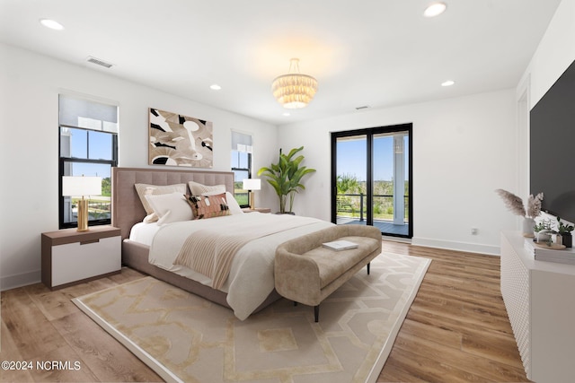 bedroom with wood-type flooring and access to exterior